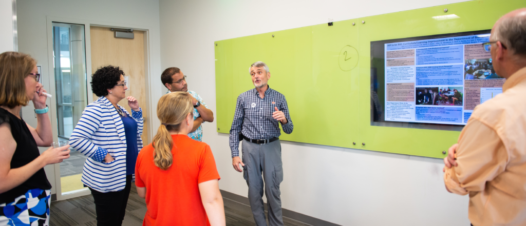 Photo: Bob Boyd showcases Biology's Learning Improvement Project at the year one celebration event hosted by Biggio Center and Academic Assessment in fall 2018.