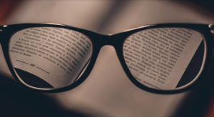 Photo of eyeglasses. Text through the lenses looks clear while other text is blurred.