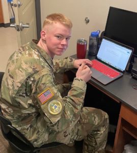 photo of a cadet writing on his laptop